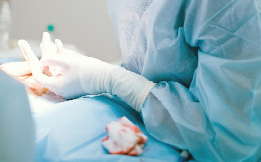 Gloved hands of a medical worker during a procedure
