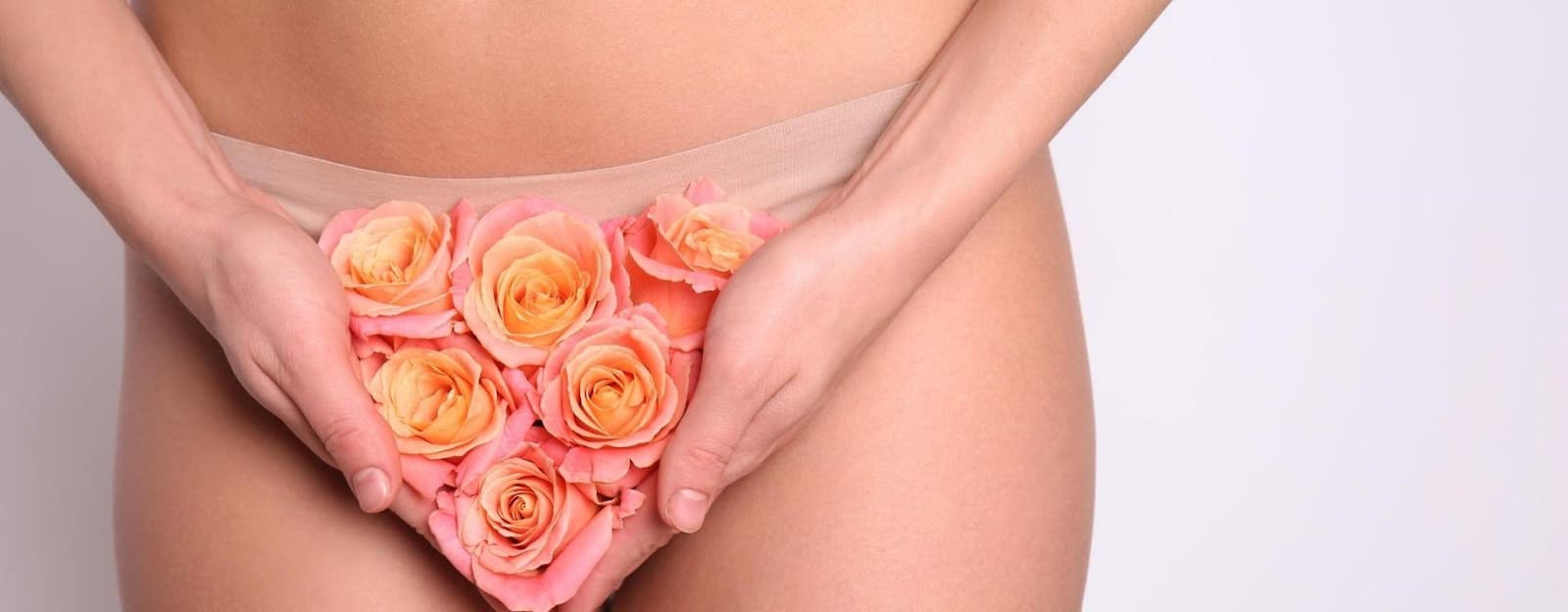A girl stands and holds roses near her panties