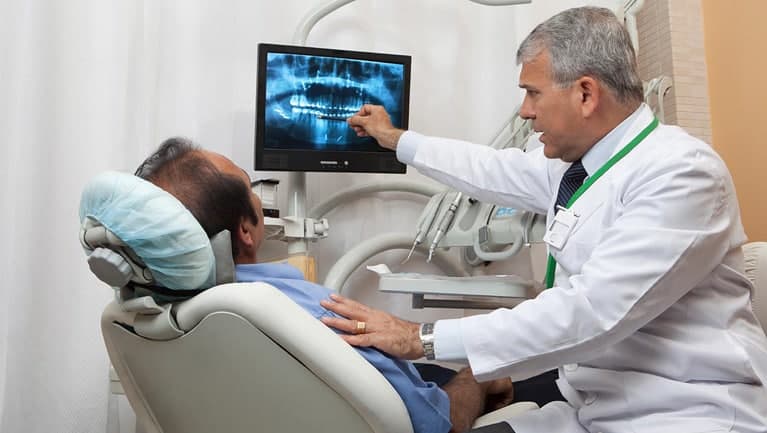 Dentist communicates with the patient in the dental chair